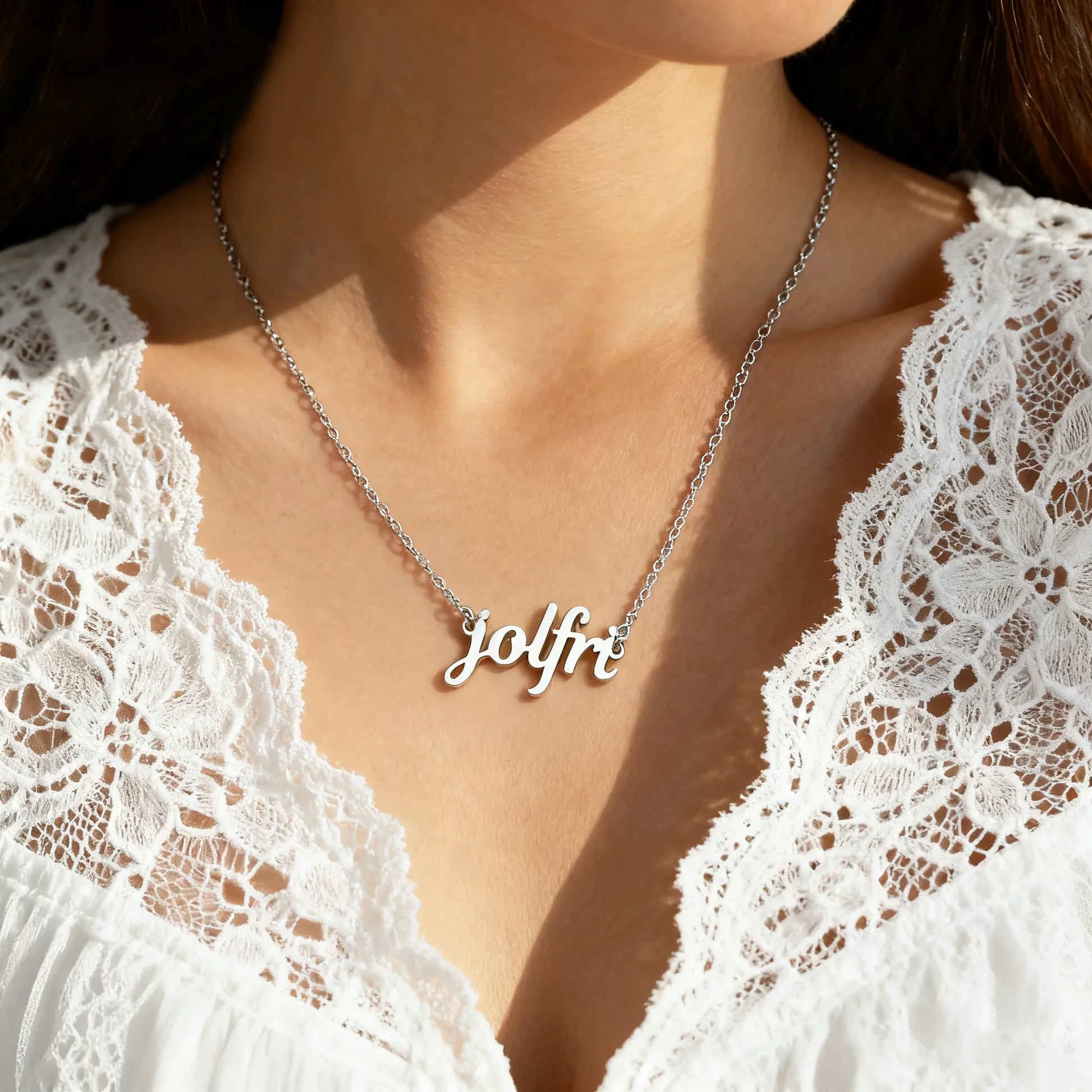 Woman wearing silver custom name necklace, layered chains, lace top