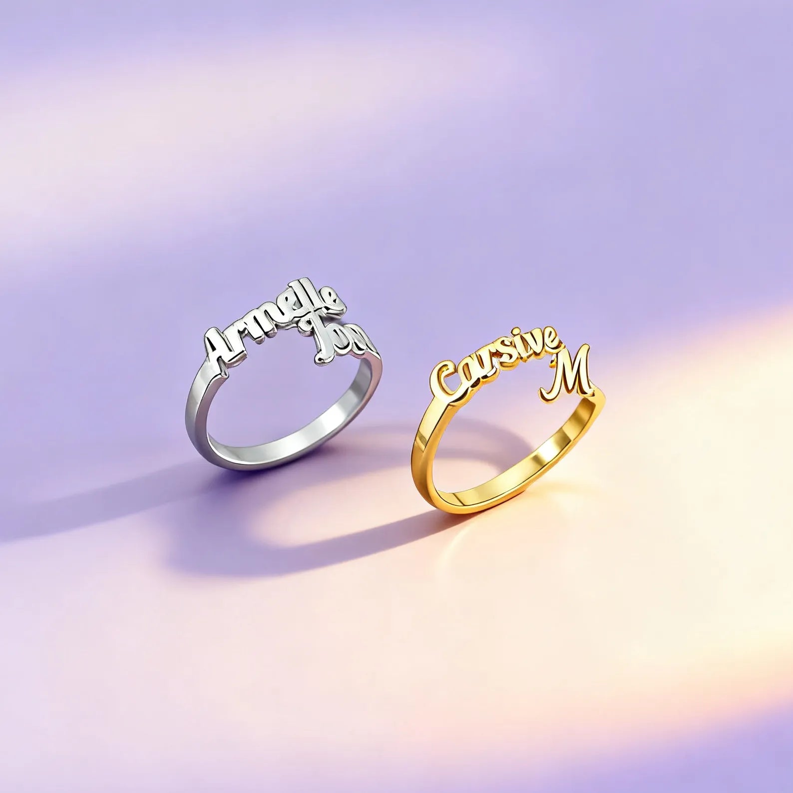 Gold and silver personalized name rings in cursive on satin background