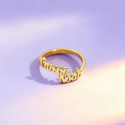 Gold ring with 'Carson Noah' engraving on a gradient purple and pink background